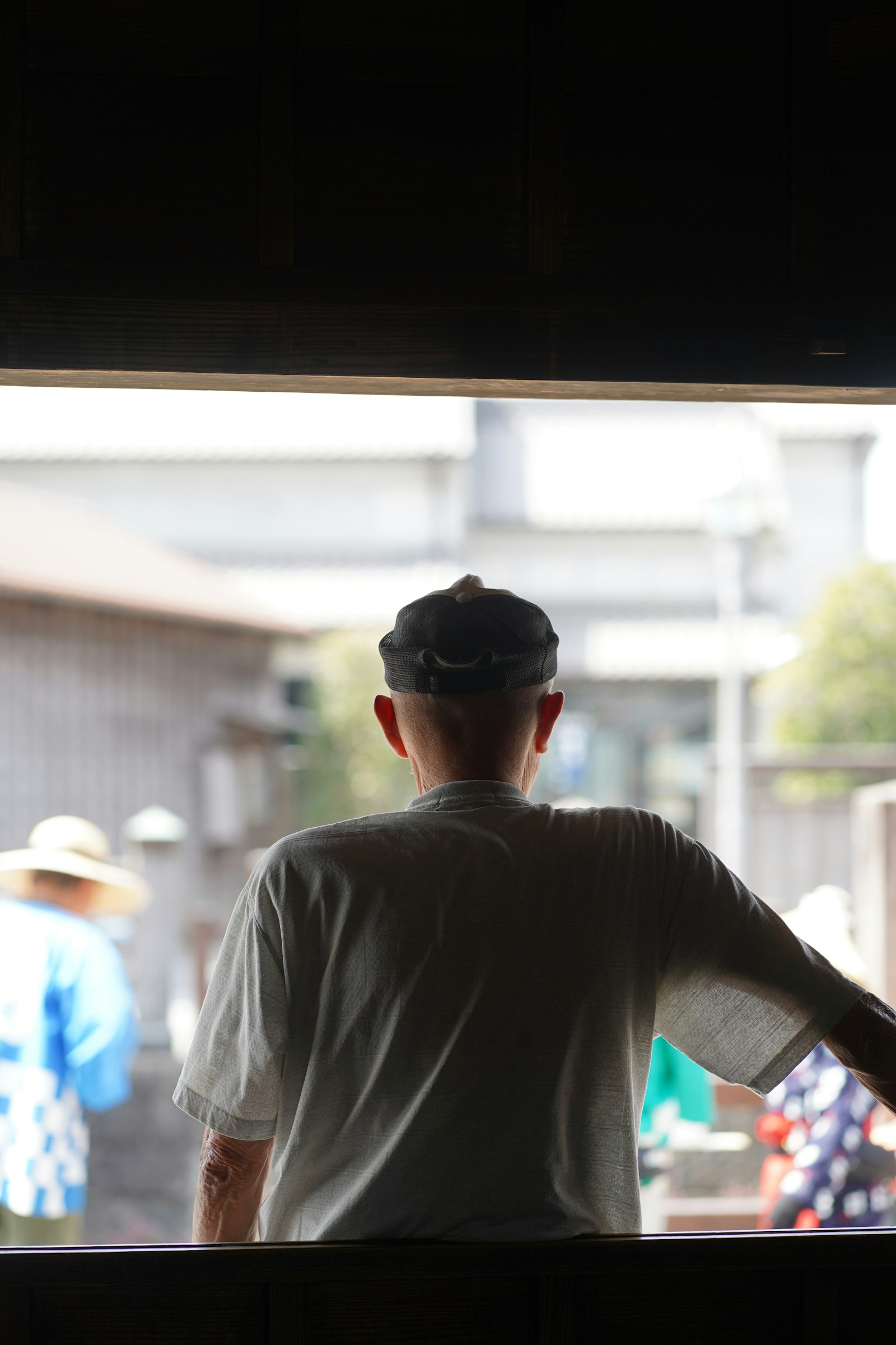 縁側から庭を眺める栄一の後ろ姿